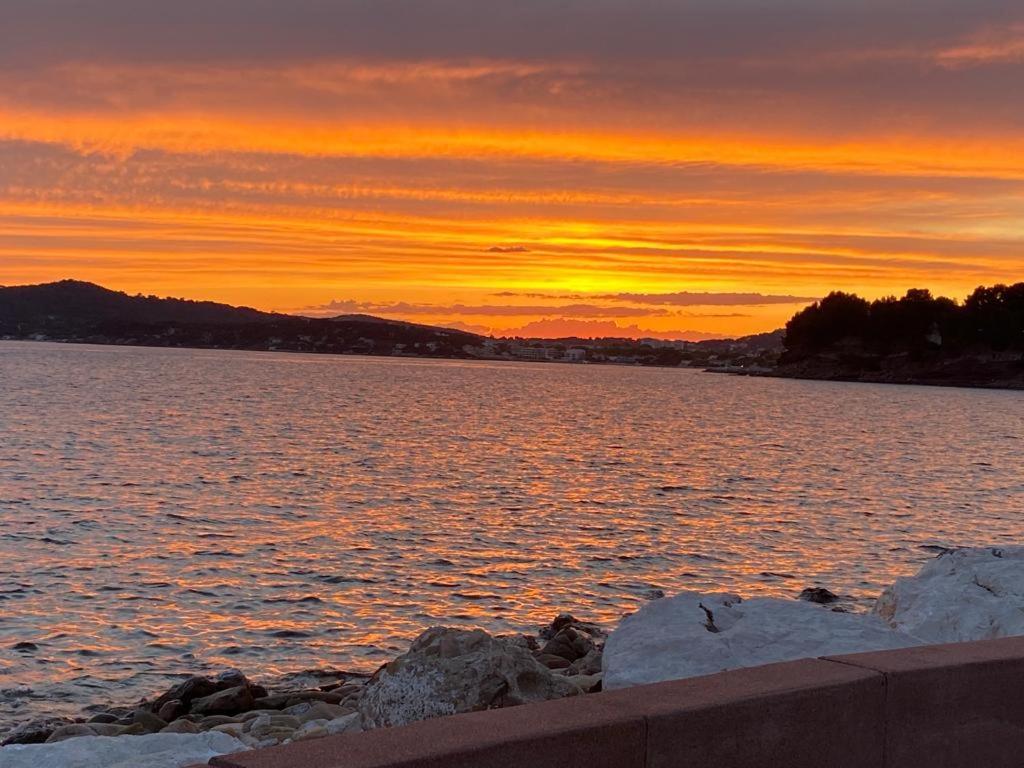 un coucher de soleil sur une grande étendue d'eau dans l'établissement Studio tout confort 100m plage, à Saint-Mandrier-sur-Mer