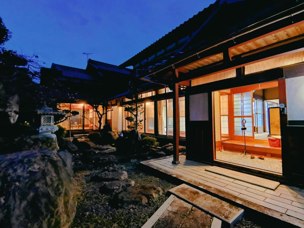 a house with a large window and a wooden deck at 大湖人家　田園風景を眺めなれる、ゆったりとしたゴージャスな屋敷 in Taga