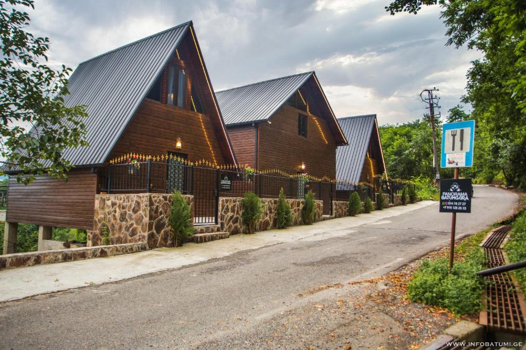 a large wooden house with a fence next to a street at Panorama BatumGora in Batumi