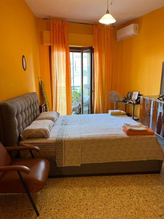a bedroom with a bed and a chair in it at Scalea City Center Apartments in Scalea