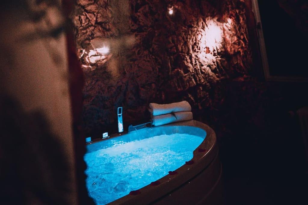 ein Badezimmer mit einer blauen Badewanne in einer Steinwand in der Unterkunft Love Cottage 2 mit Whirlpool in Hagen