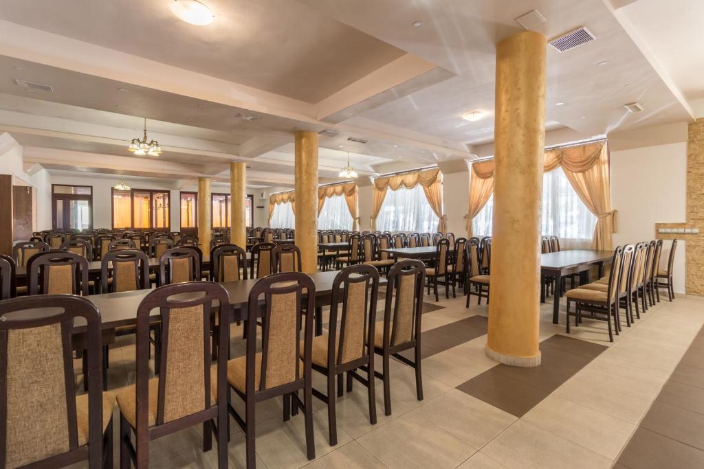 a dining room with a long table and chairs at Pensiunea Popasul Ursilor in Chişcău