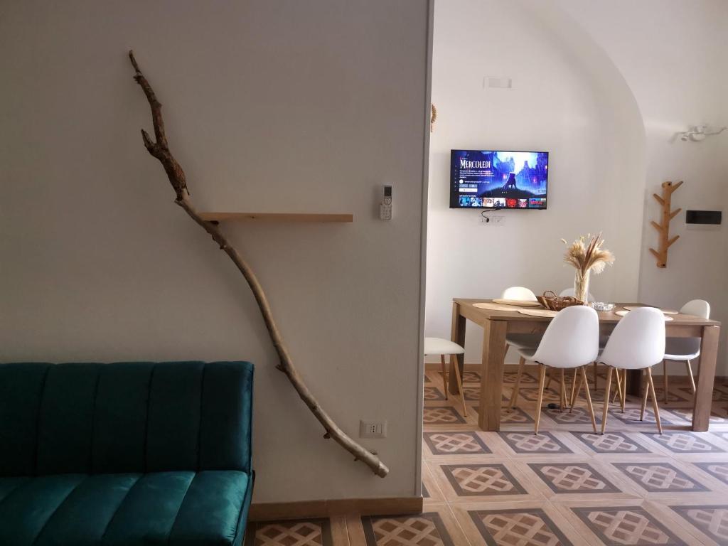 ein Wohnzimmer mit einem Tisch und einem Ast an der Wand in der Unterkunft Appartamento Porta Lecce in Brindisi