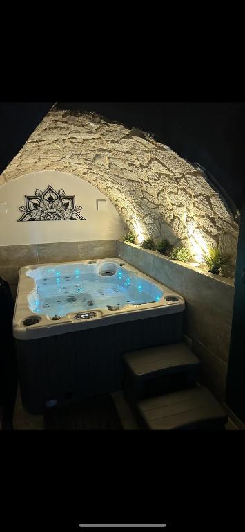 une baignoire jacuzzi avec des escaliers dans un mur en pierre dans l'établissement Love room La Parenthèse Carnoules, à Carnoules