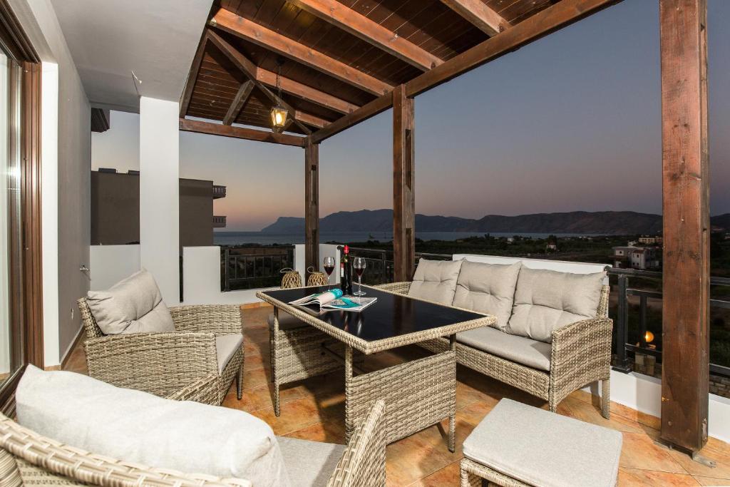 a patio with wicker chairs and a table with a view at Ora Kalí in Korfalónas