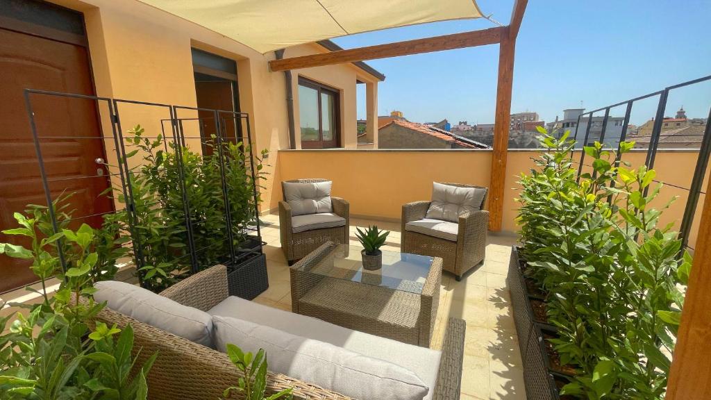 un patio con sedie e un tavolo sul balcone. di Welcomely - Xenia Boutique Tirso a Oristano