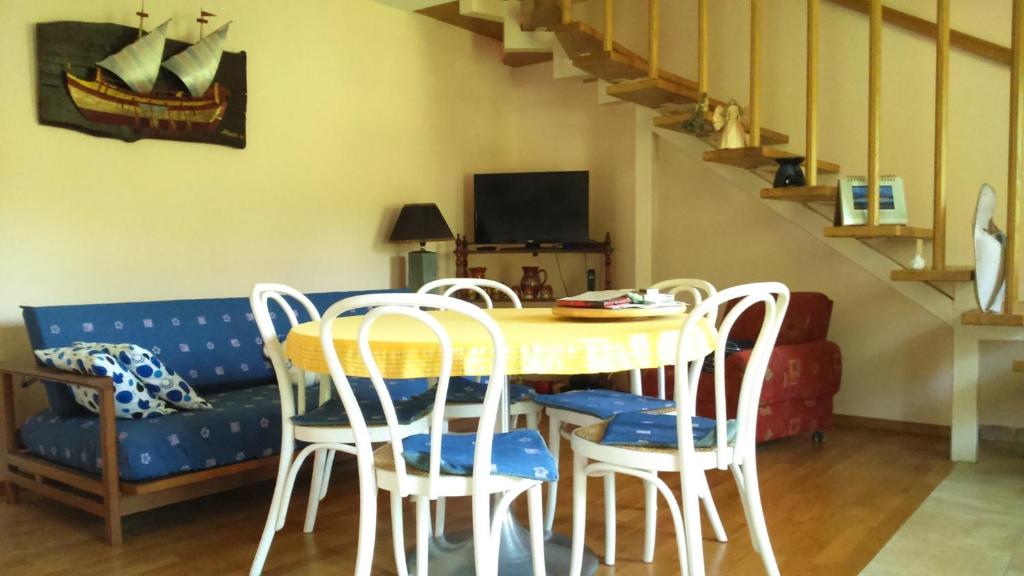 a dining room with a table and chairs and a couch at Country House Trnac in Tuhelj