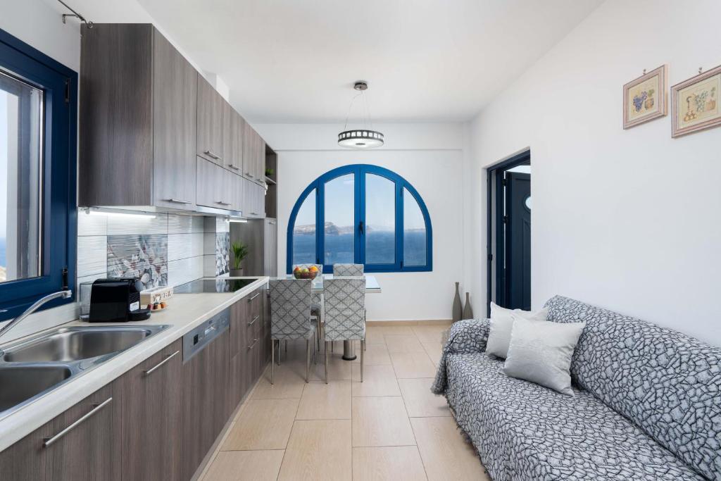 a living room with a couch and a kitchen at Caldera Heights Apartment in Akrotiri