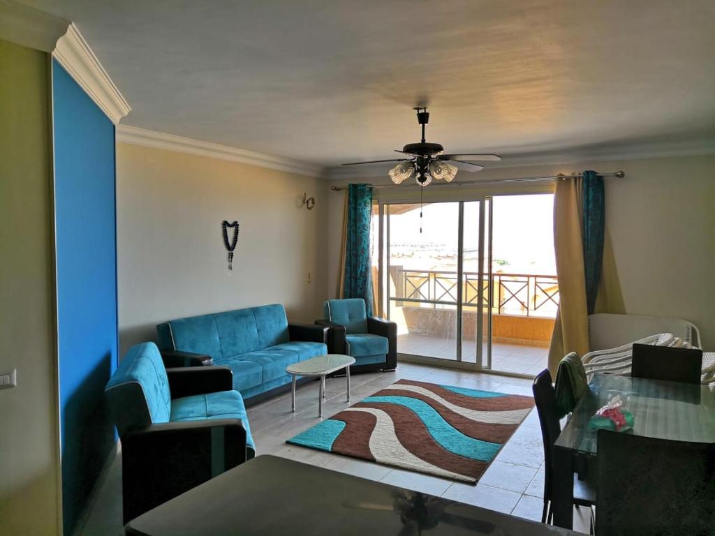 a living room with a blue couch and a table at Challet Lavista Topaz in Ain Sokhna