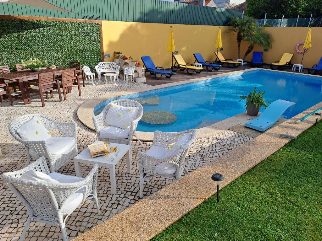 einen Pool mit Stühlen, einem Tisch und Stühlen in der Unterkunft Quinta Salinas - Puro Prazer in Aveiro