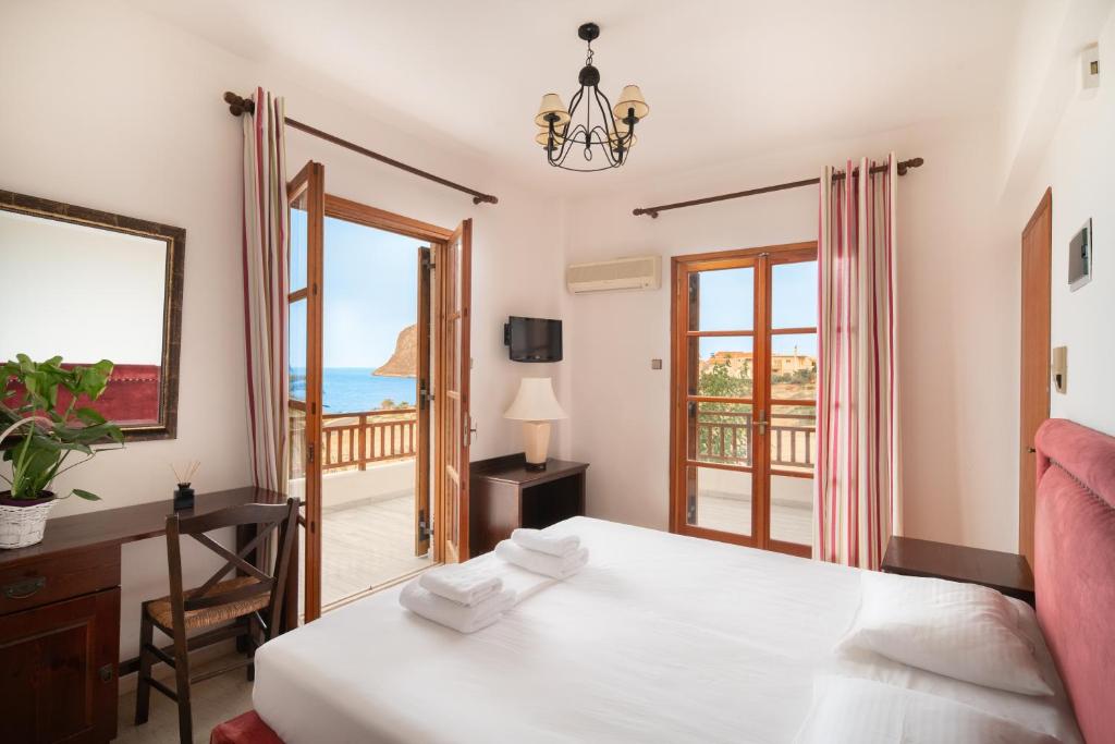 a bedroom with a bed and a view of the ocean at Alta Vista Studios - ex Lekka's House in Monemvasia