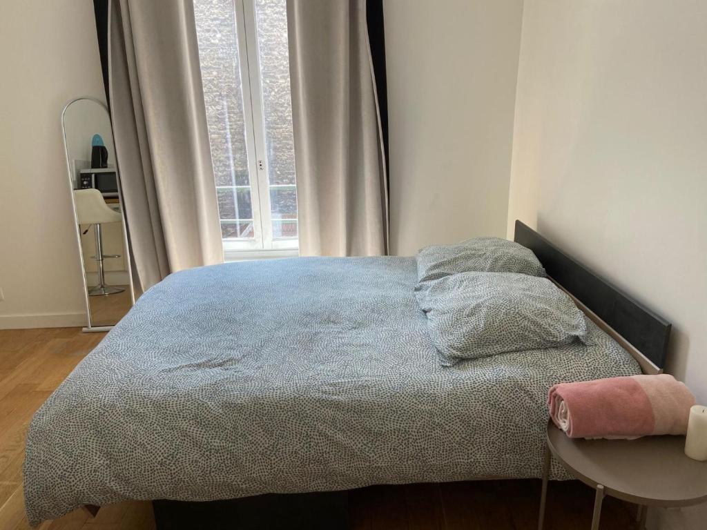 a bedroom with a bed with a table and a window at Studio quai de Valmy in Paris