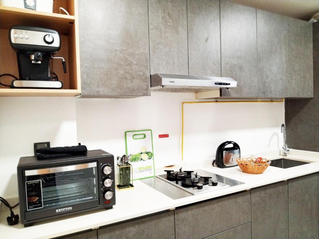 a kitchen with a toaster oven and a microwave at Cozy Apartment in Jumeirah Village Circle, Dubai. in Dubai