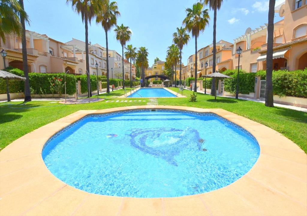 a large swimming pool in a yard with palm trees at Casa Altamar I Javea - 5009 in Jávea
