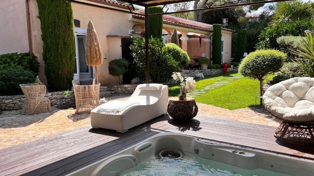 un patio trasero con piscina con silla y sombrilla en Chez Virginie, en Porto Vecchio