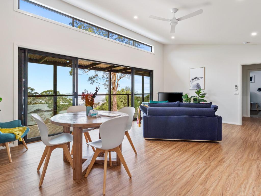 a living room with a table and chairs and a couch at Top of the Bay in Arthurs Seat