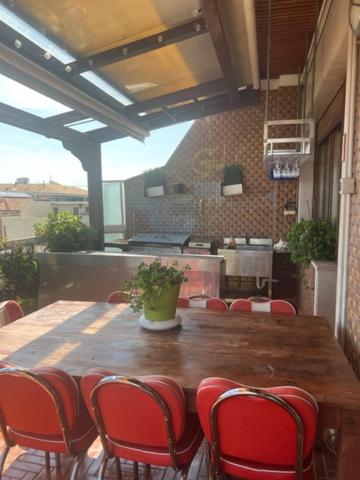 - une table en bois avec des chaises rouges dans la cuisine dans l'établissement Stella di mare, à Pescara