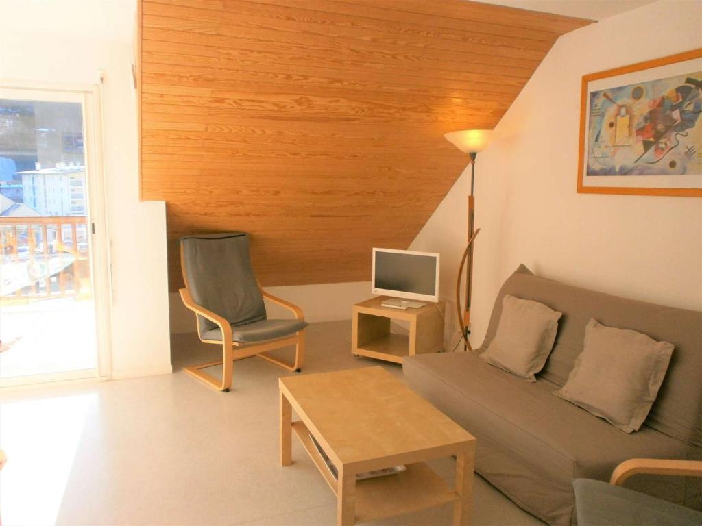 ein Wohnzimmer mit einem Sofa, einem Tisch und einem TV in der Unterkunft Appartement Saint-Lary-Soulan, 3 pièces, 6 personnes - FR-1-457-130 in Saint-Lary-Soulan