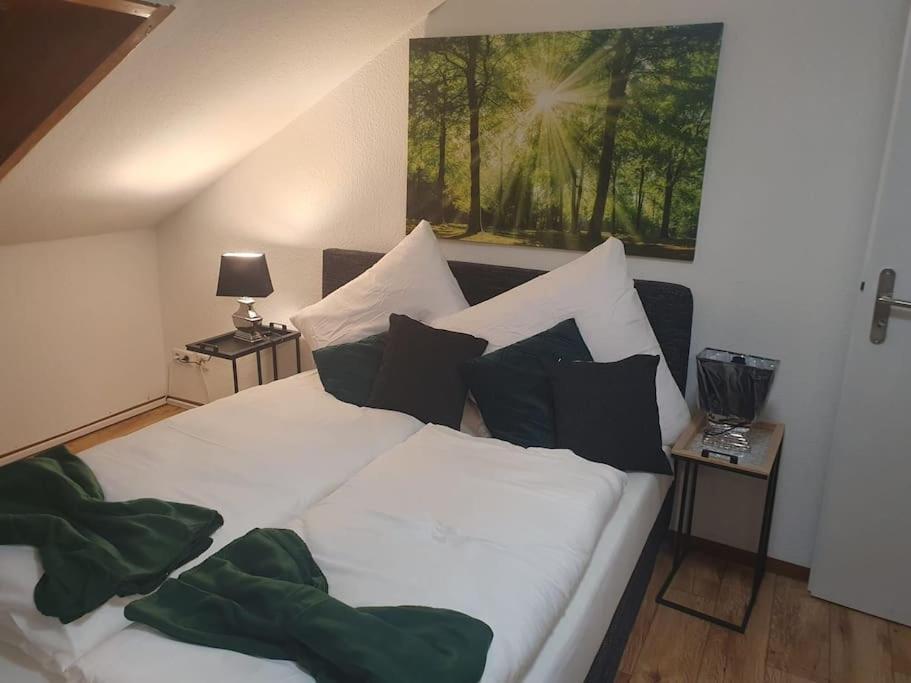 ein Schlafzimmer mit einem weißen Bett und schwarzen Kissen in der Unterkunft Waterfalls Apartment in Triberg
