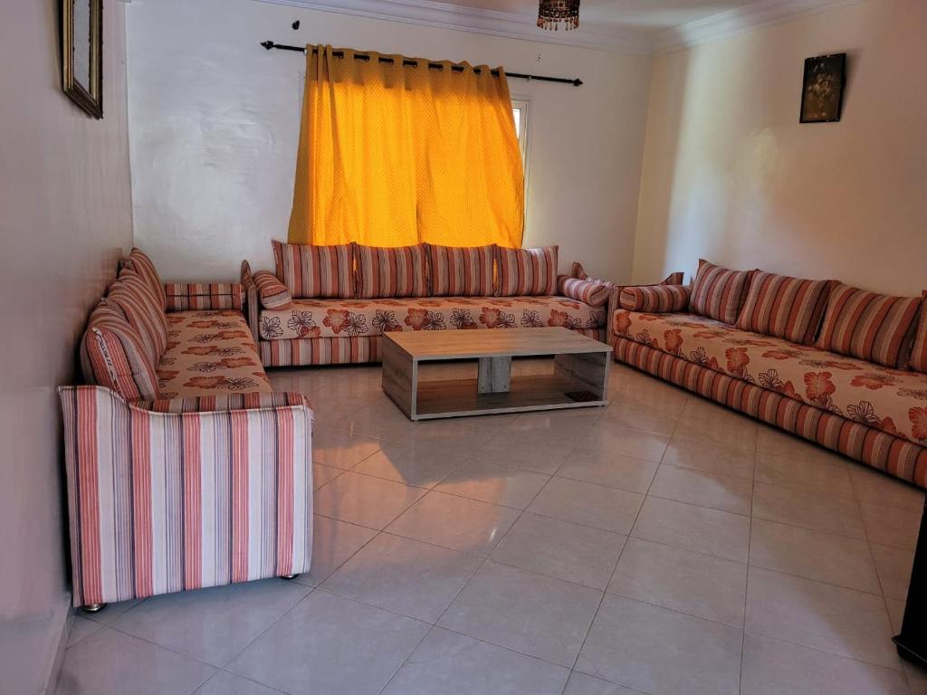 a living room with couches and a coffee table at Duplex avec piscine - Sidi Bouzid in El Jadida