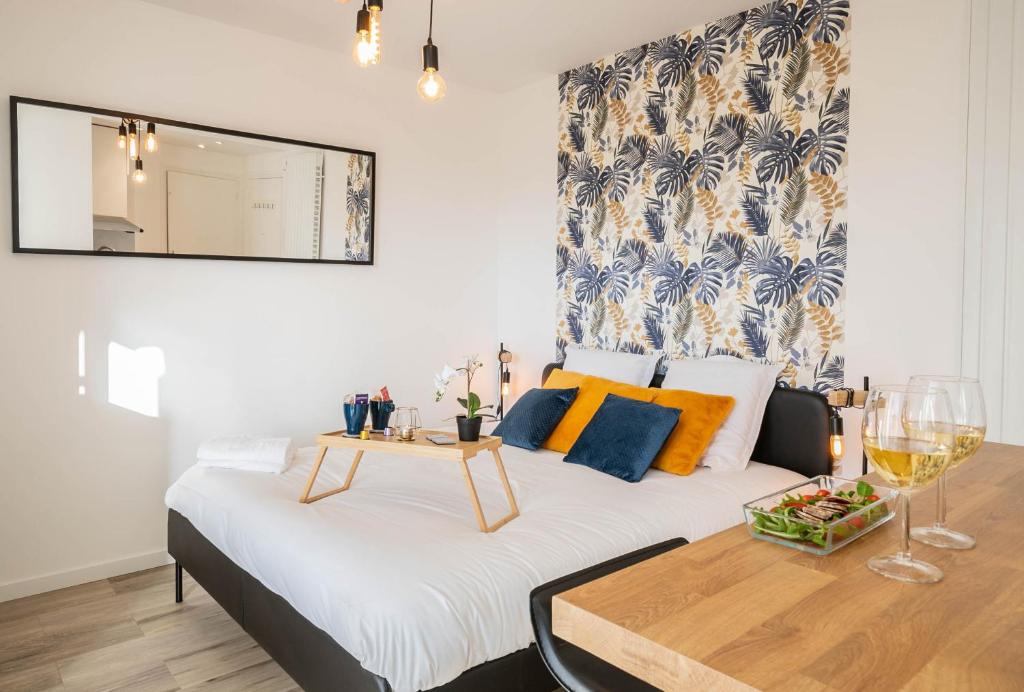 Cette chambre comprend un lit et une table avec des verres à vin. dans l'établissement Woody 100m du lac balcon, à Annecy