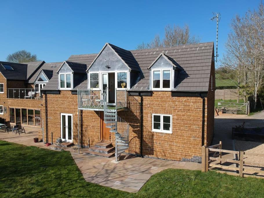 a brick house with a staircase in front of it at Field View in Braunston