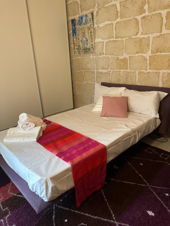 uma cama num quarto ao lado de uma parede de tijolos em Luxury room in Gharghur em Għargħur