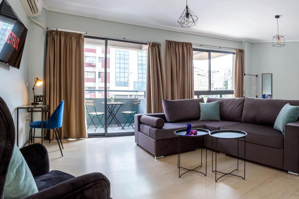 een woonkamer met een bank en een tafel bij Sunny studio apartment in Thessaloniki city center in Thessaloniki