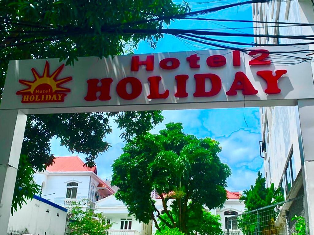 a sign for a hotel holiday in front of a building at Holiday Hotel 2 in An Khê