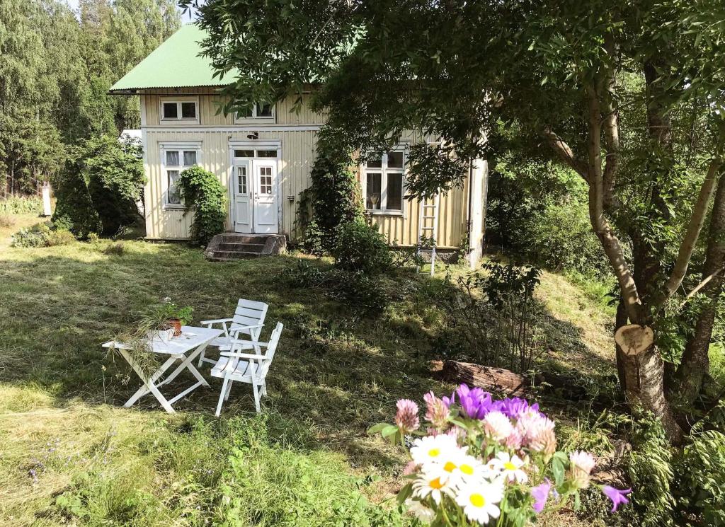 a house with a table and chairs in the yard at Lakeside Guesthouse in Ramvik