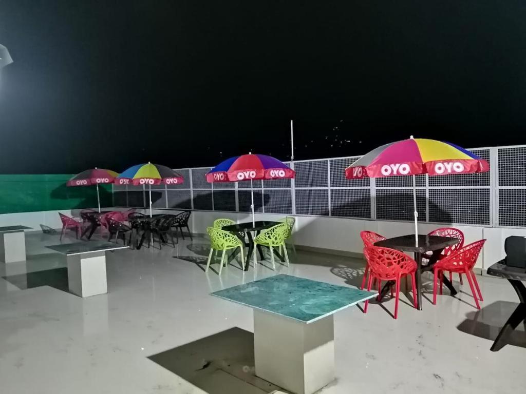 a group of tables with colorful chairs and umbrellas at The Bagain in Shimla