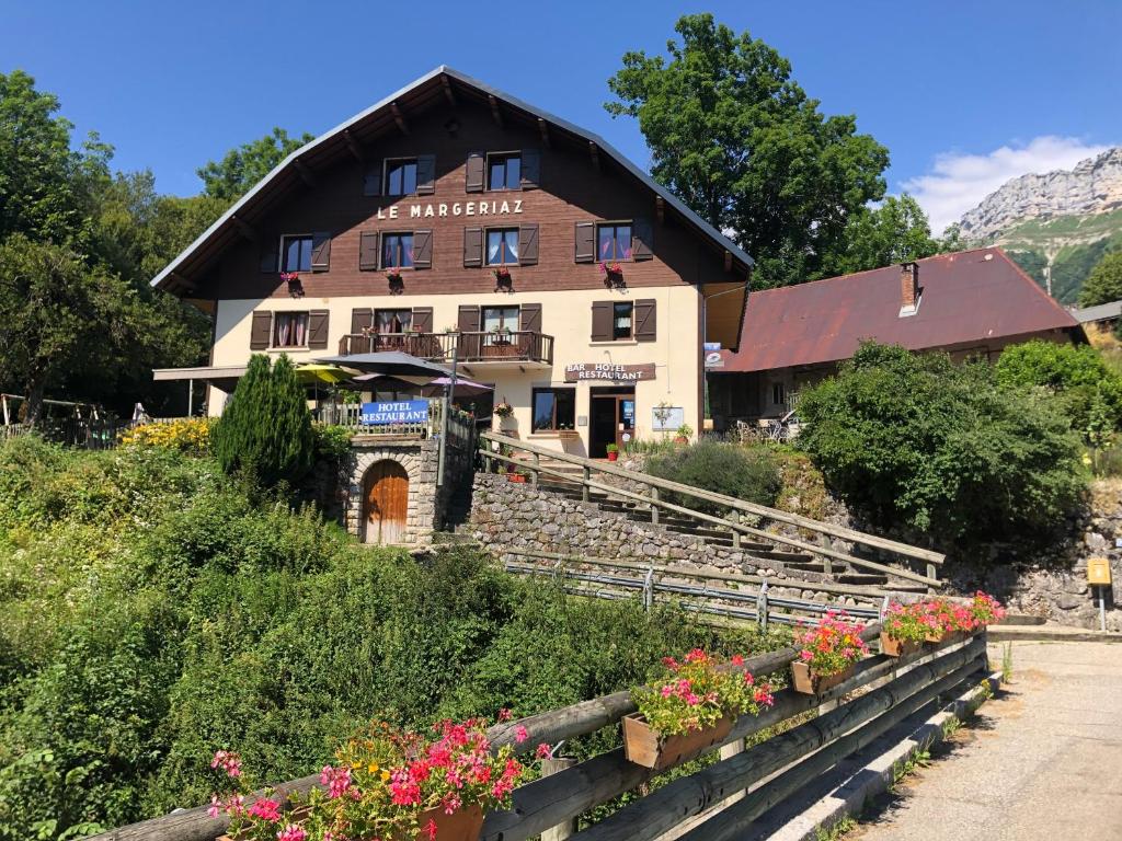 a building with flowers in front of it at Bar Hotel Restaurant le Margeriaz in Les Déserts