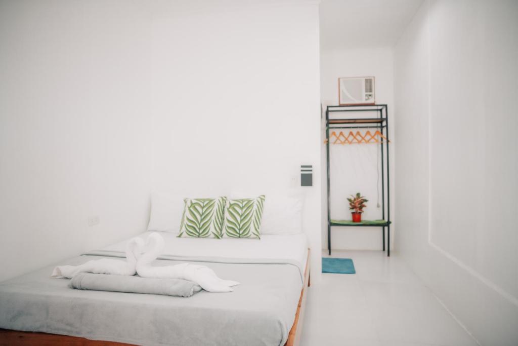 a white room with a bed and a mirror at Greendales - New Extension in Puerto Princesa City