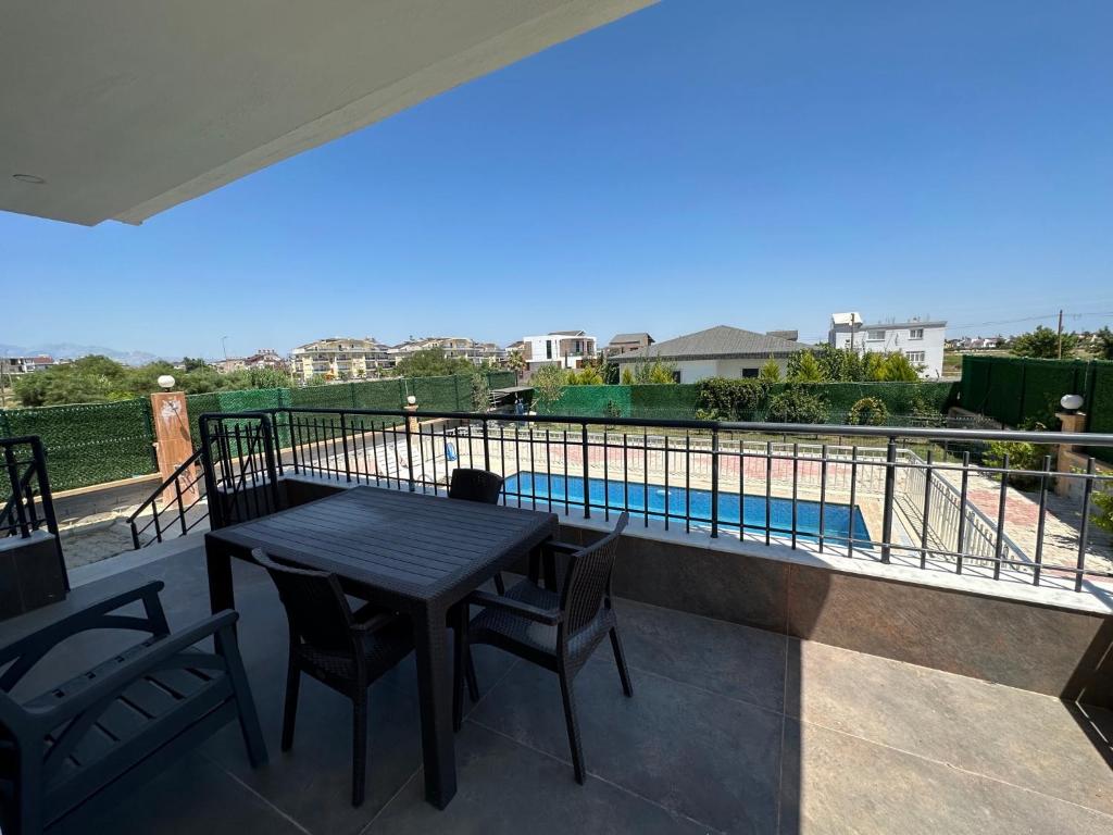 a balcony with a table and chairs and a swimming pool at the land of legend luxury in Belek