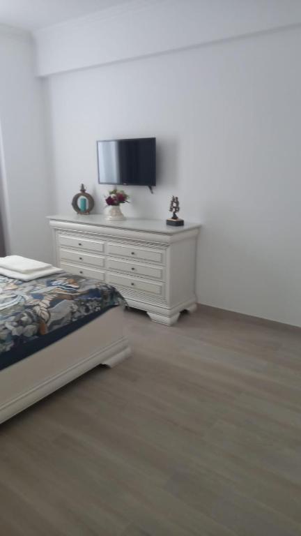 een slaapkamer met een bed en een tv op een dressoir bij Campus in Constanţa