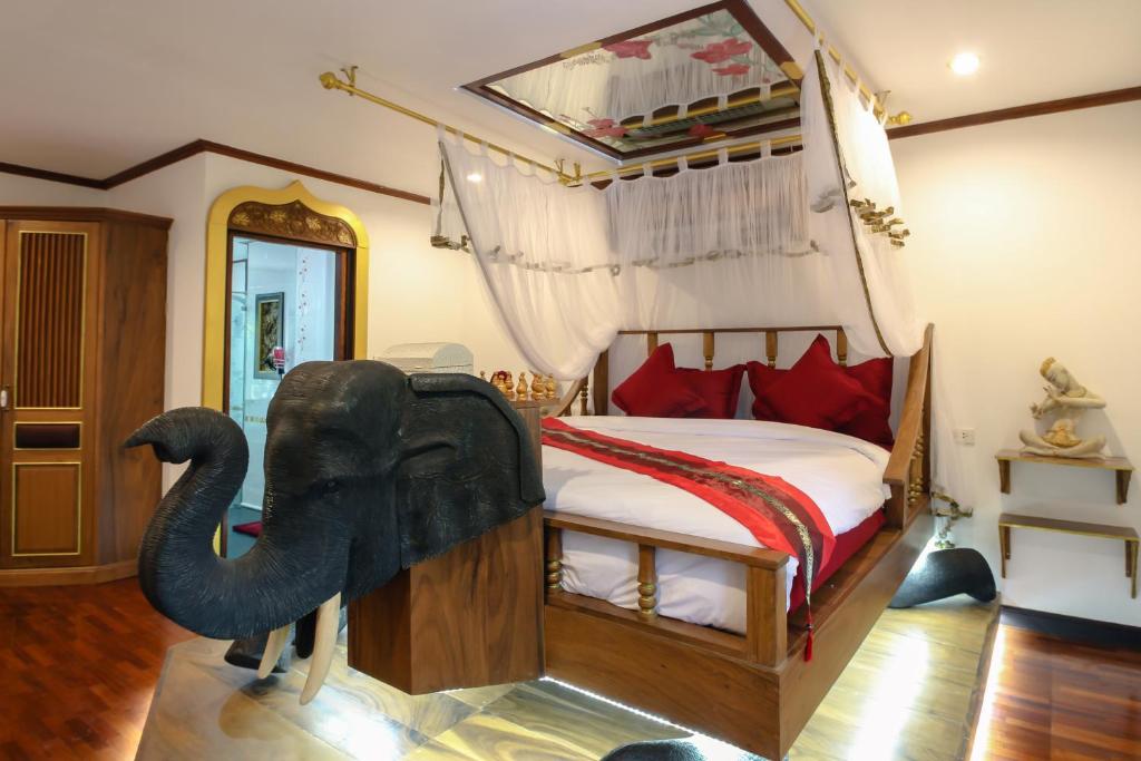 a bedroom with an elephant statue on a bed at Olivier Boutique in Chiang Mai