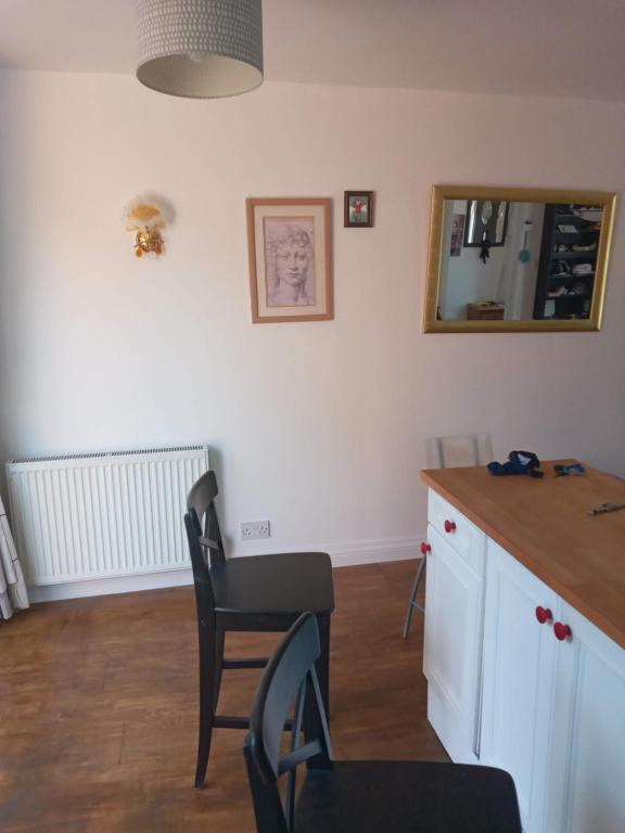 een keuken met een aanrecht, 2 stoelen en een spiegel bij Morgan Ease in Manchester