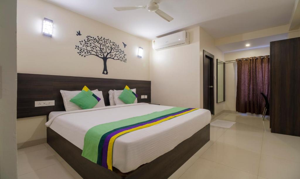 een slaapkamer met een groot bed met een boom aan de muur bij Treebo Trend MVP Grand in Visakhapatnam