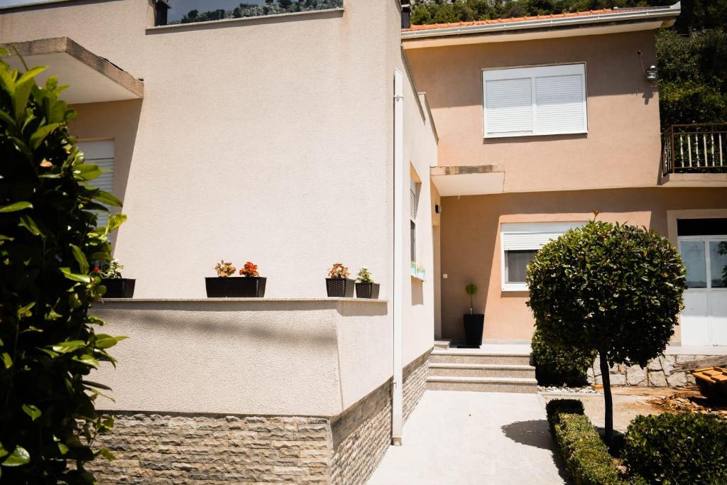 uma casa com vasos de plantas numa varanda em Apartman Villa Vita em Capljina
