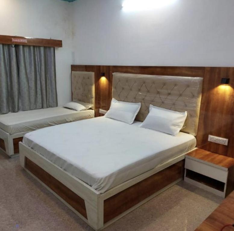 um quarto com 2 camas e almofadas brancas em SHREE ATITHI HIGHWAY HOTEL em Ābu Road