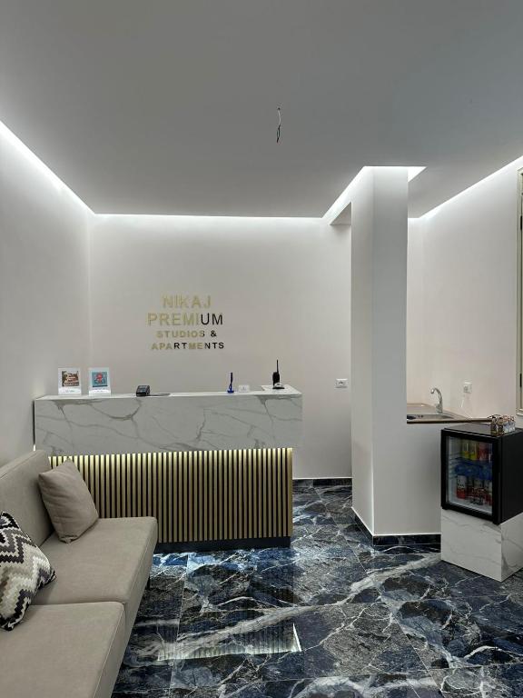 a living room with a couch and a tv at Nikaj Premium Apart-Hotel in Vlorë