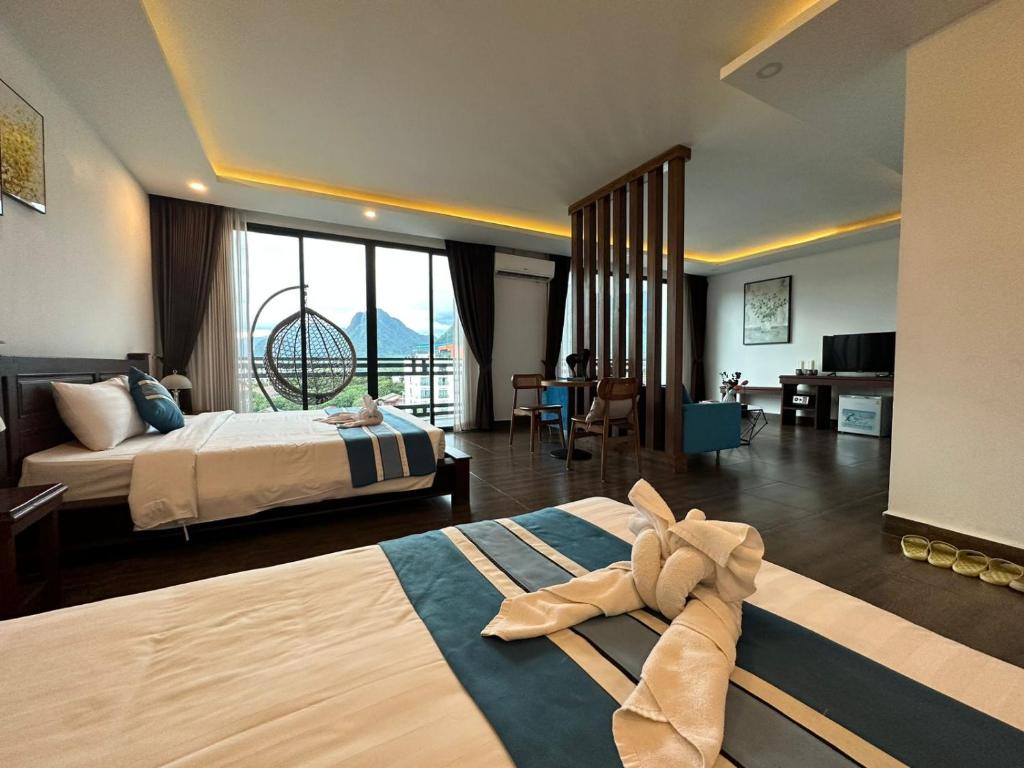 Habitación de hotel con 2 camas y sala de estar. en VANG VIENG TOPVIEW HOTEL, en Vang Vieng