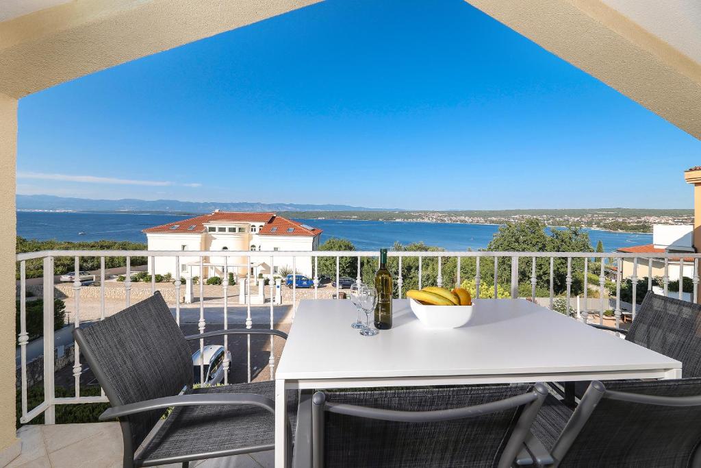 a white table and chairs on a balcony at Sea view by Moro in Malinska