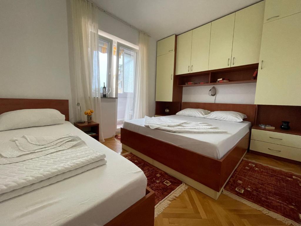 1 dormitorio con 2 camas y ventana grande en Apartment Bacio en Petrovac na Moru