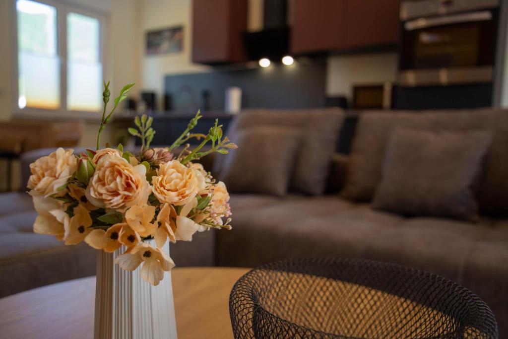 Un jarrón con flores sobre una mesa en una sala de estar. en Ferienwohnung Philipp, en Traben-Trarbach