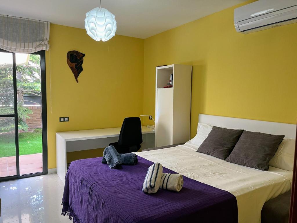 カニェレスにあるWashingtonia Villa near Sitgesのベッドルーム(紫の毛布付きのベッド1台付)