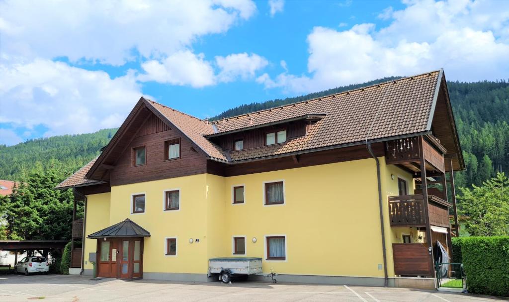 a large yellow building with a brown roof at Haus Nora by Globalimmoservice in Bad Kleinkirchheim