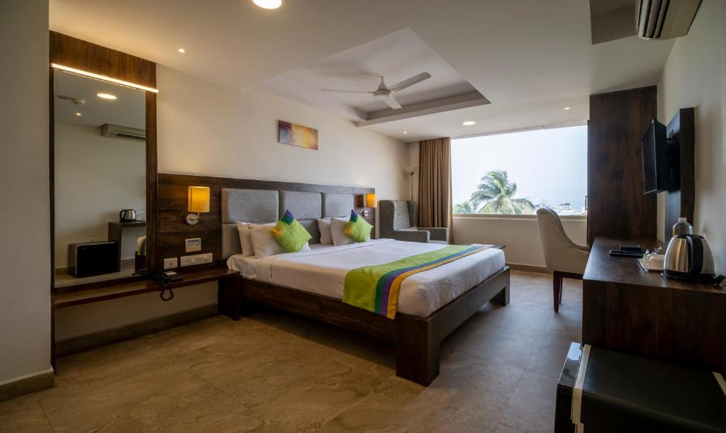 a hotel room with a bed and a television at Treebo Trend PL Grand Vishakapatnam in Visakhapatnam