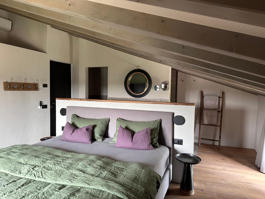 1 dormitorio con 1 cama grande con almohadas moradas en CA`NOVA AGRITURISMO, en Castellaro