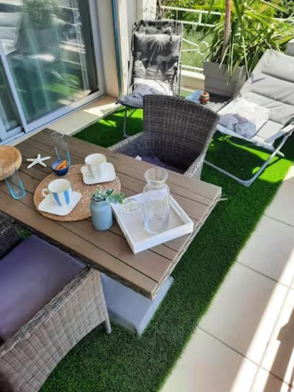 - une table avec de la vaisselle sur la terrasse dans l'établissement Studio Croix des Gardes Palais Plages, à Cannes